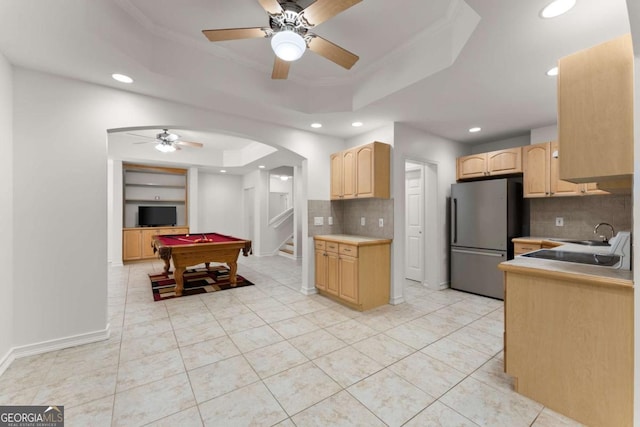 kitchen with freestanding refrigerator, light brown cabinetry, billiards, a raised ceiling, and a ceiling fan