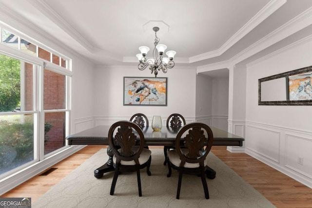 dining room featuring a chandelier, ornamental molding, and wood finished floors