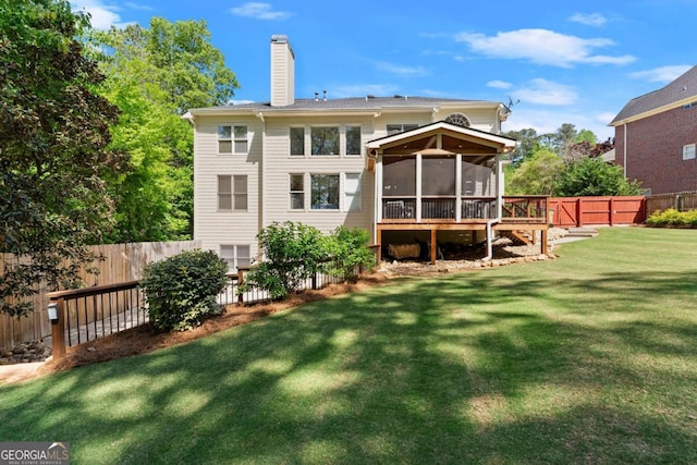back of property featuring a lawn, a fenced backyard, a sunroom, and a chimney