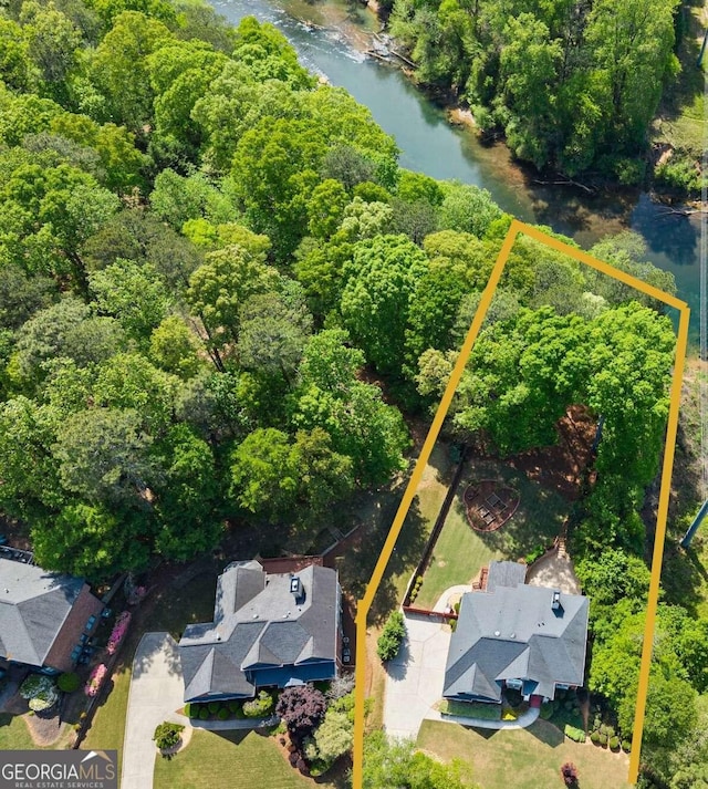 birds eye view of property with a water view and a forest view