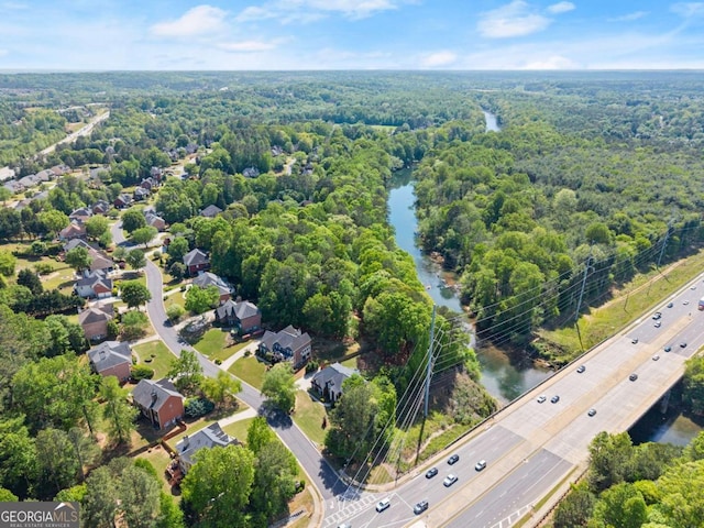 drone / aerial view with a water view and a view of trees