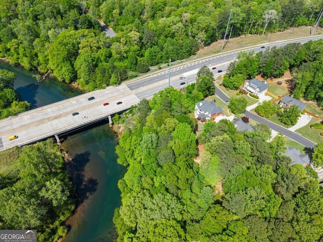 drone / aerial view featuring a water view and a forest view