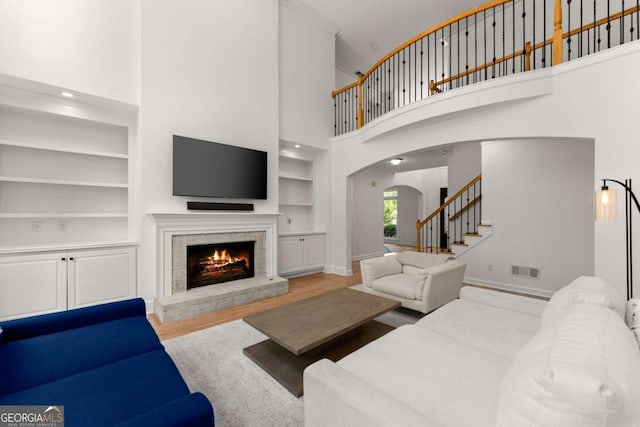 1900 Chattahoochee Run Dr, Suwanee, GA 30024 - living area with built in features, stairway, arched walkways, a brick fireplace, and baseboards
