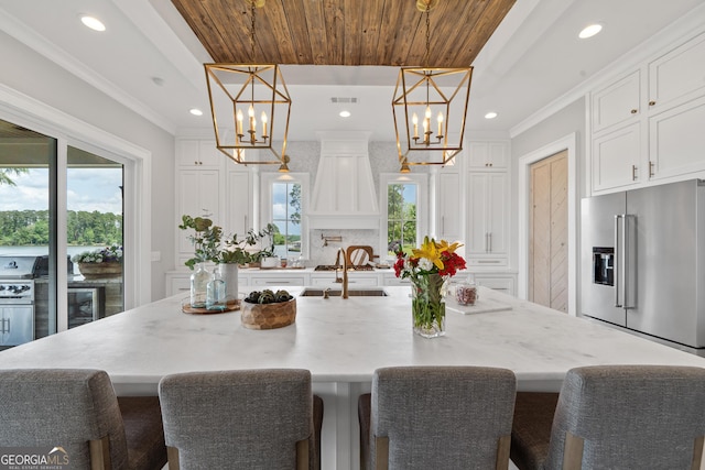 239 Lakeshore Cir, Milledgeville, GA 31061 - kitchen featuring a chandelier, a healthy amount of sunlight, high end refrigerator, and a spacious island