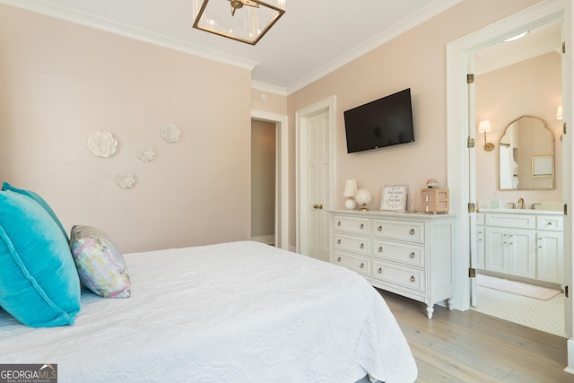 239 Lakeshore Cir, Milledgeville, GA 31061 - bedroom with connected bathroom, light wood-style flooring, ornamental molding, a sink, and a notable chandelier