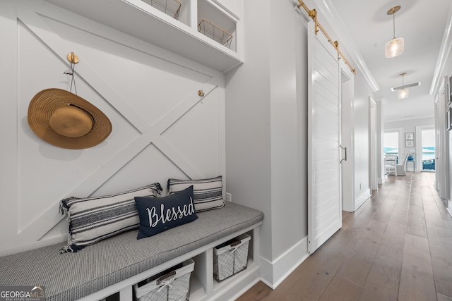 239 Lakeshore Cir, Milledgeville, GA 31061 - mudroom featuring a barn door, ornamental molding, wood-type flooring, and baseboards
