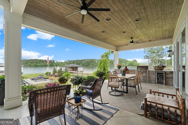 239 Lakeshore Cir, Milledgeville, GA 31061 - view of patio / terrace with a ceiling fan, a water view, exterior kitchen, and beverage cooler