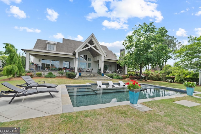 239 Lakeshore Cir, Milledgeville, GA 31061 - back of property featuring roof with shingles, an outdoor pool, a yard, and a patio area