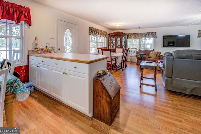 2000 Campbell Rd, Covington, GA 30014 - kitchen with light wood-style floors, a peninsula, white cabinets, and light countertops