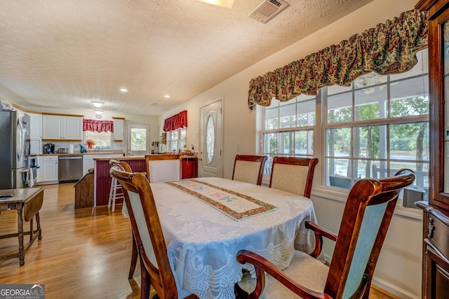 2000 Campbell Rd, Covington, GA 30014 - dining space with light wood-type flooring, a textured ceiling, and recessed lighting