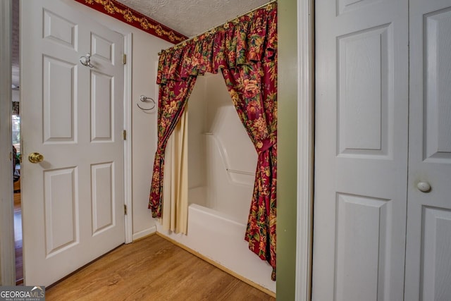 2000 Campbell Rd, Covington, GA 30014 - bathroom featuring wood finished floors, shower / tub combo with curtain, and a textured ceiling