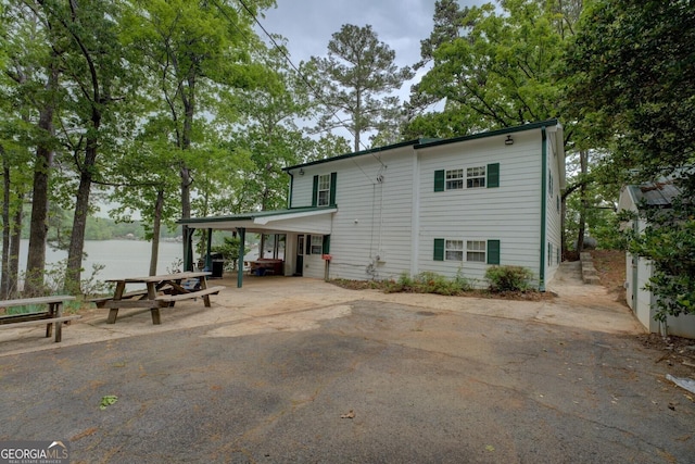 2000 Campbell Rd, Covington, GA 30014 - rear view of house with asphalt driveway, a water view, a patio area, and a carport