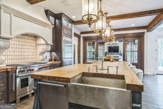 kitchen with a notable chandelier, butcher block countertops, dark brown cabinets, and premium appliances