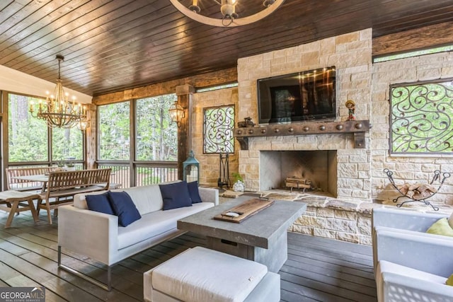 living area featuring hardwood / wood-style floors, a notable chandelier, a stone fireplace, and wooden ceiling