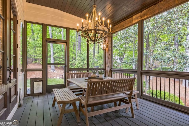sunroom / solarium featuring outdoor dining area and a notable chandelier