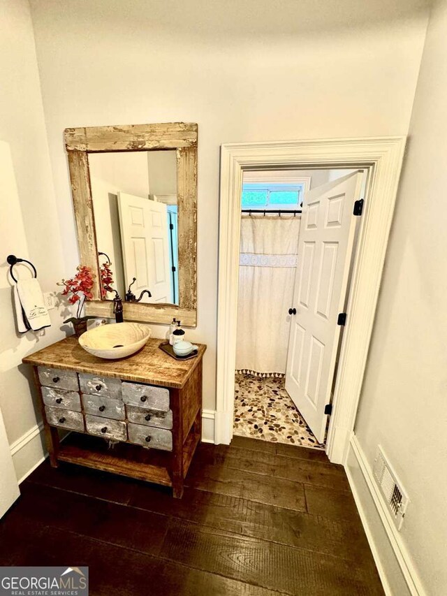 bathroom featuring vanity, wood-type flooring, visible vents, baseboards, and a shower with shower curtain