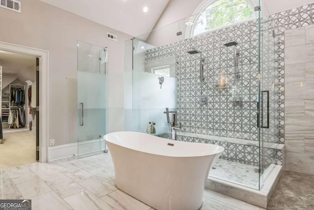 full bath with visible vents, a shower stall, and vaulted ceiling