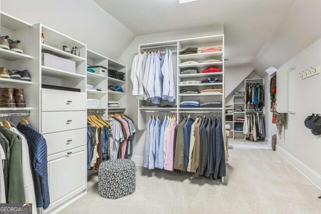 walk in closet featuring carpet flooring and vaulted ceiling