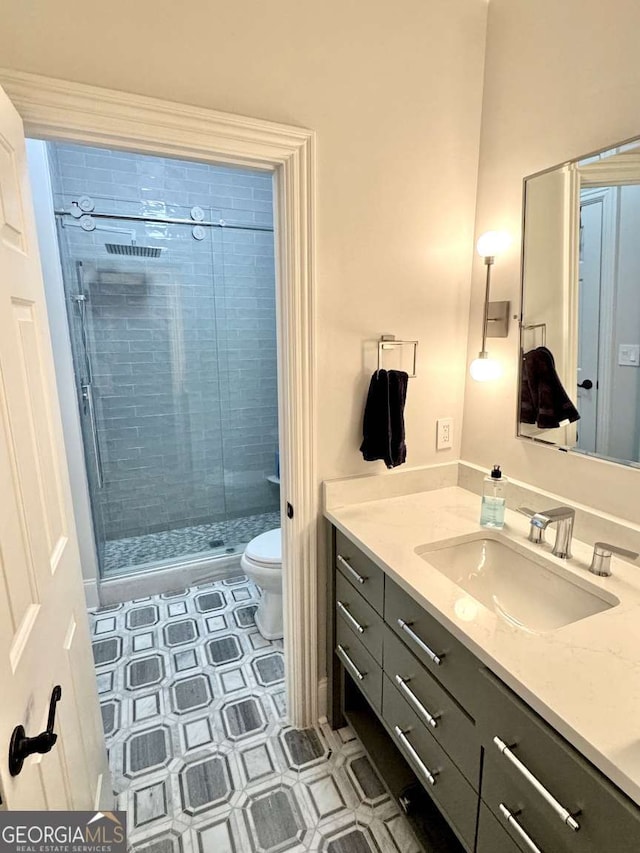 bathroom with tile patterned floors, a shower stall, toilet, and vanity