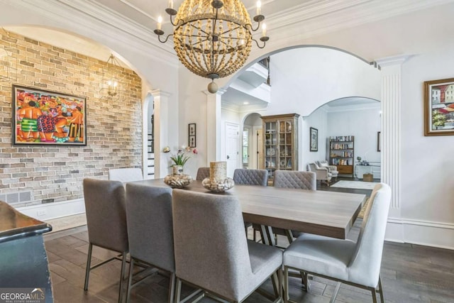dining area featuring an inviting chandelier, decorative columns, crown molding, arched walkways, and wood finished floors