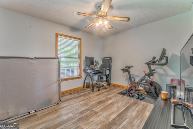 office space with baseboards, wood finished floors, and ceiling fan