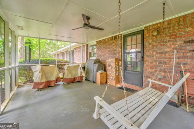 unfurnished sunroom featuring visible vents and a ceiling fan