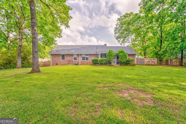 ranch-style house with a front yard, a fenced backyard, and brick siding