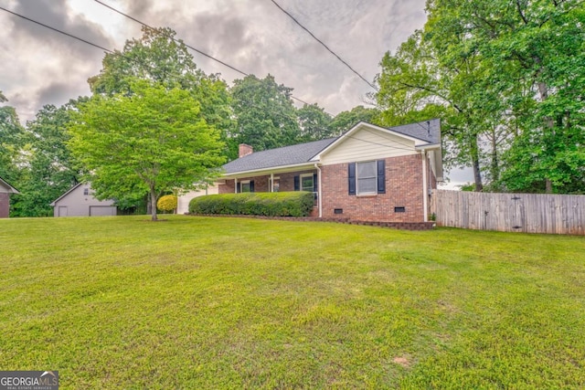 view of front of house with brick siding, fence, a front lawn, and crawl space