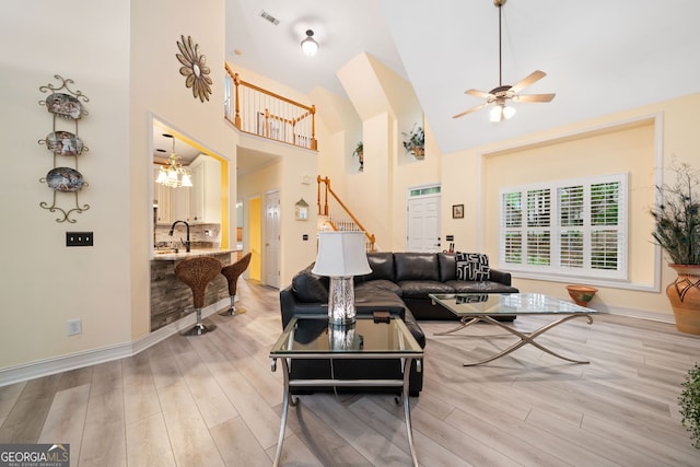 122 Woodstream Pt, Big Canoe, GA 30143 - living room featuring ceiling fan, light wood-style floors, high vaulted ceiling, visible vents, and stairway