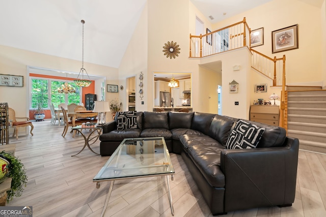 122 Woodstream Pt, Big Canoe, GA 30143 - living room featuring stairway, a high ceiling, light wood-style flooring, and a notable chandelier