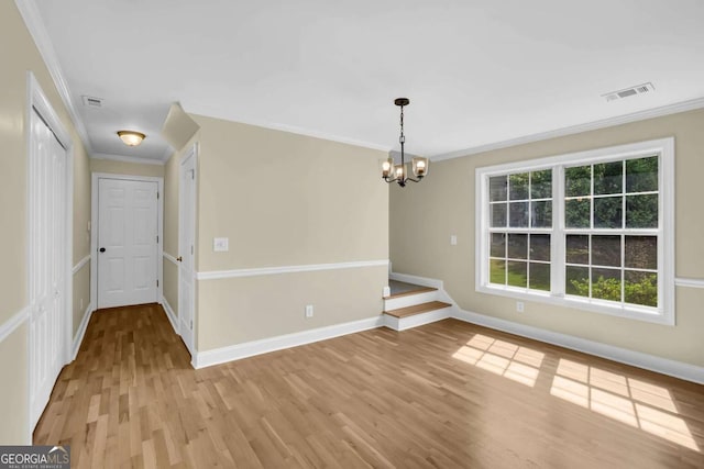unfurnished dining area with visible vents, crown molding, baseboards, a chandelier, and light wood finished floors