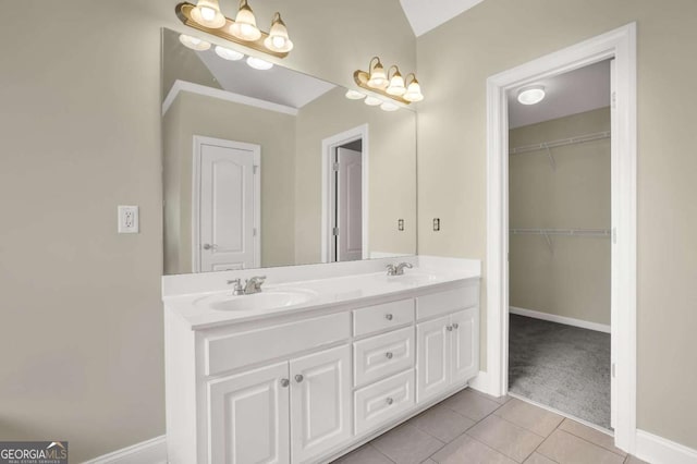 full bathroom with double vanity, a sink, baseboards, and tile patterned flooring