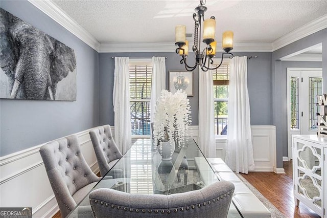 10 Callaway Ct, Hiram, GA 30141 - dining space with a textured ceiling, a chandelier, ornamental molding, wood finished floors, and wainscoting