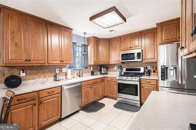 10 Callaway Ct, Hiram, GA 30141 - kitchen with appliances with stainless steel finishes, light countertops, brown cabinets, tasteful backsplash, and a textured ceiling