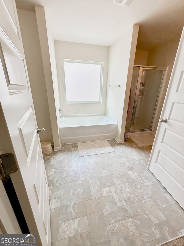 573 Emporia Loop, Mcdonough, GA 30253 - full bathroom with baseboards, a stall shower, and a garden tub