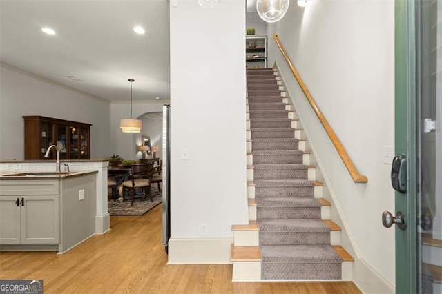 719 Hammond Dr, Woodstock, GA 30188 - stairs featuring wood finished floors, ornamental molding, and recessed lighting