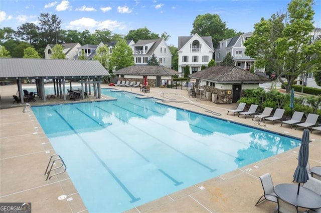 community pool featuring a residential view and a patio area