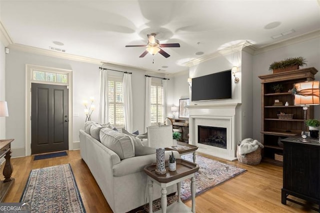 719 Hammond Dr, Woodstock, GA 30188 - living area featuring a ceiling fan, crown molding, a fireplace, and light wood-style flooring