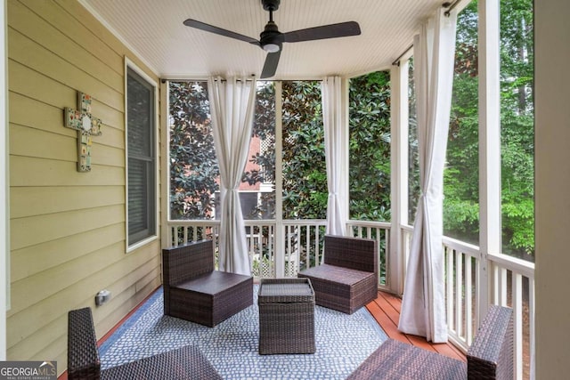 sunroom / solarium with ceiling fan and wooden walls