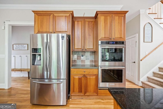 kitchen featuring dark stone countertops, brown cabinets, and stainless steel appliances