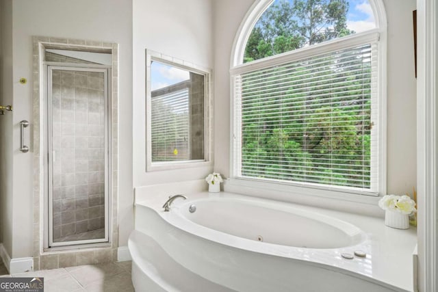 full bath featuring plenty of natural light, a garden tub, and a stall shower