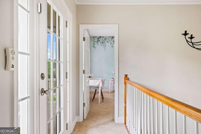 corridor featuring light colored carpet, baseboards, and crown molding