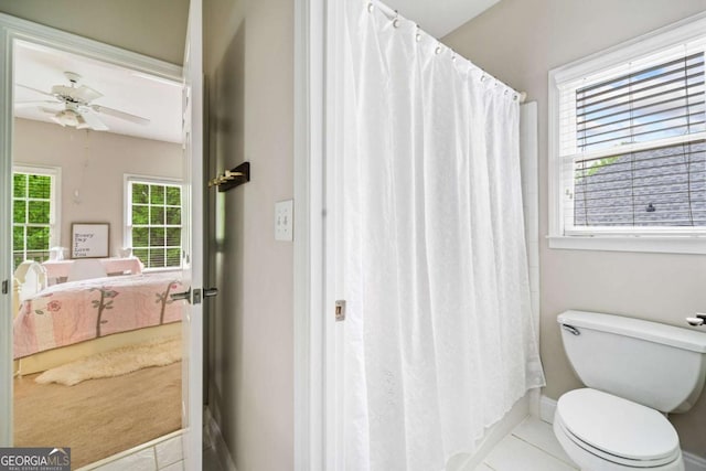 ensuite bathroom featuring ceiling fan, baseboards, tile patterned floors, toilet, and connected bathroom