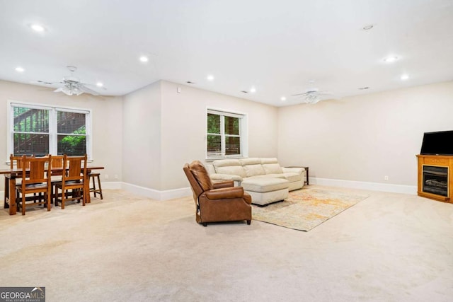 living area featuring a ceiling fan, baseboards, light colored carpet, and recessed lighting