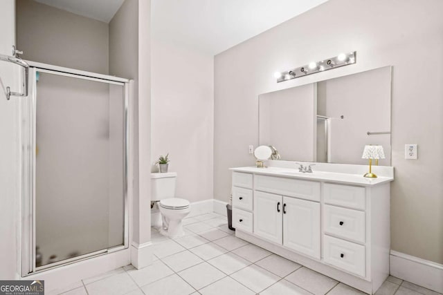 bathroom featuring tile patterned flooring, a shower stall, vanity, baseboards, and toilet