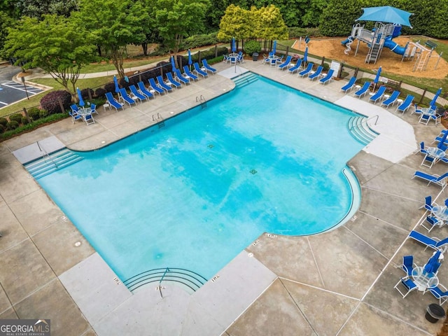 pool with a patio area and playground community