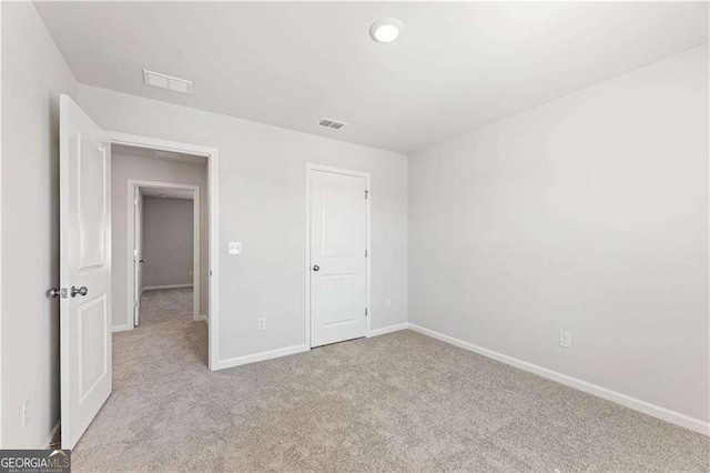 unfurnished bedroom featuring baseboards, visible vents, and carpet flooring