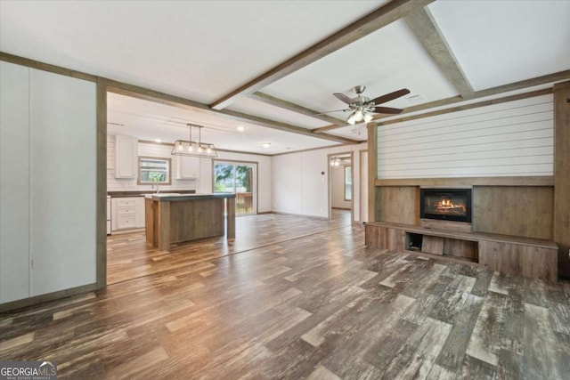 1293 Lake Dr, Midway, GA 31320 - unfurnished living room featuring ceiling fan, a glass covered fireplace, and wood finished floors