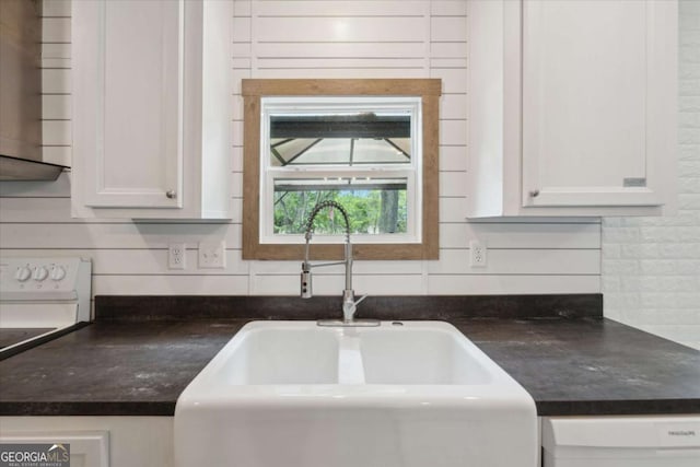 1293 Lake Dr, Midway, GA 31320 - room details with a sink, dark countertops, dishwashing machine, and white cabinetry