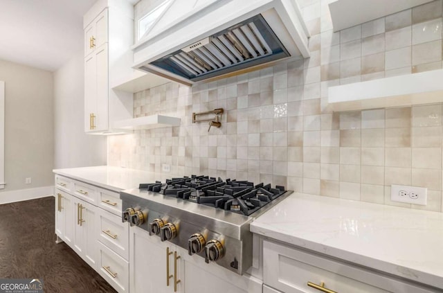 kitchen featuring white cabinets, stainless steel gas cooktop, custom exhaust hood, and decorative backsplash